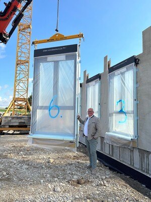 ETZI-Group-Geschäftsführer Maximilian Etzenberger präsentiert das bereits im Werk zusammengesetzte 3,5 Meter hohe Windowment-Fensterelement, welches mittels Baukran direkt in die Wand eingesetzt wird. © ETZI-Group