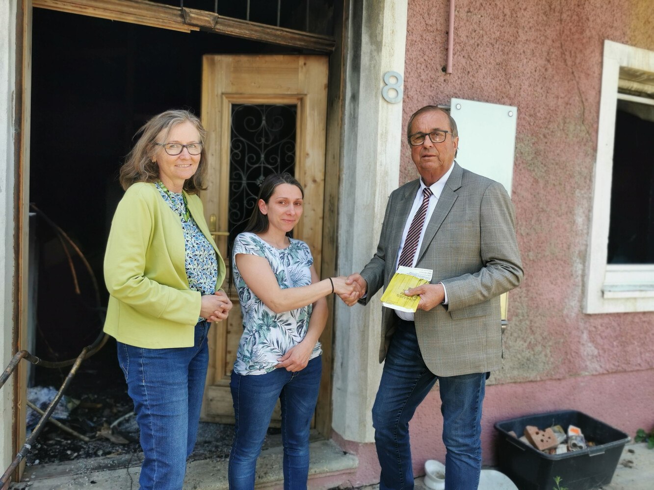 Claudia Marton und Helmut Rigler überbrachten der Witwe Sarah Kienel (Mitte) eine großzügige Spende des nö. Unterstützungsvereins, die aufgrund des großen Schadens leider nur ein Tropfen auf dem heißen Stein ist. Weitere Sach- und Geldspenden werden dringend benötigt, damit sich die junge Familie ein neues Leben aufbauen kann. © LI NÖ DGS