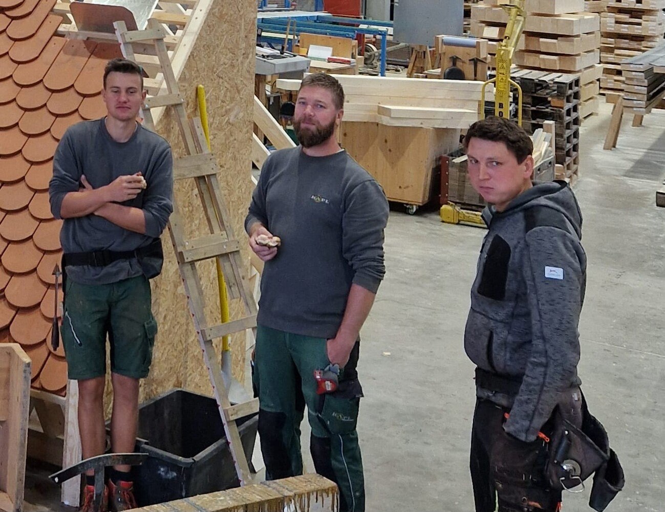 Schnappschuss in einer kurzen Pause: Die WM-Teilnehmer im Steildach-Bewerb Daniel Hofer und Bernhard Gösweiner (außen) mit Trainer Christian Gabriel.
  © Markus Geist