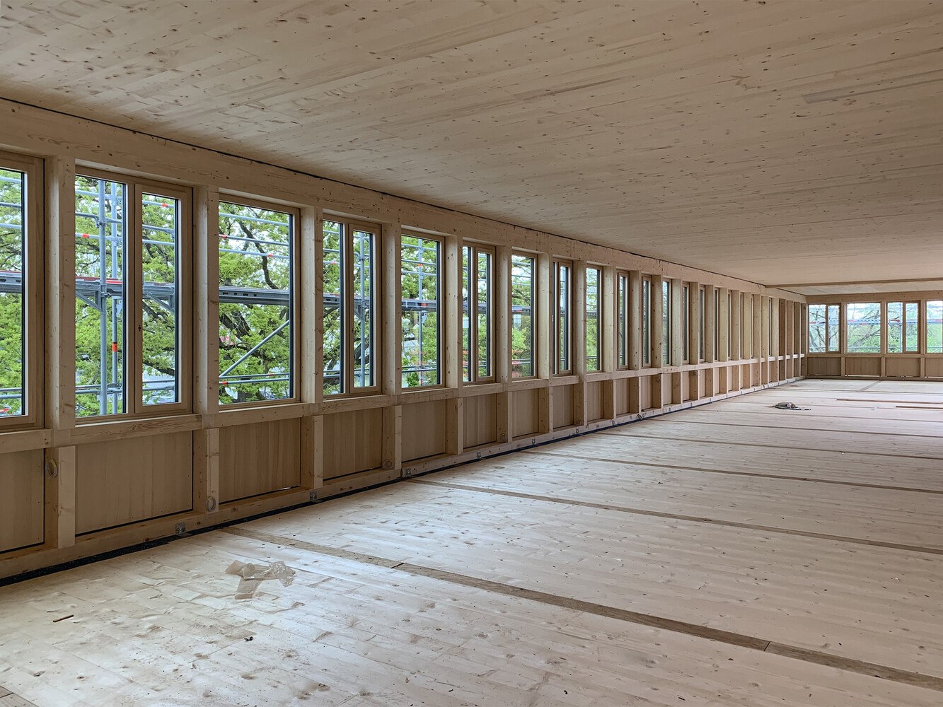 Der Holzbau entlang der Fassaden besteht aus einer Art Pfosten-Riegel-Konstruktion aus Brettschichtholz.

  © Christopher Unger