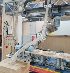 Die Cobots von Universal Robots unterstützen bei Pick-and-Place-Anwendungen und helfen außerdem bei der Bearbeitung von Möbelteilen. (c) Hussl