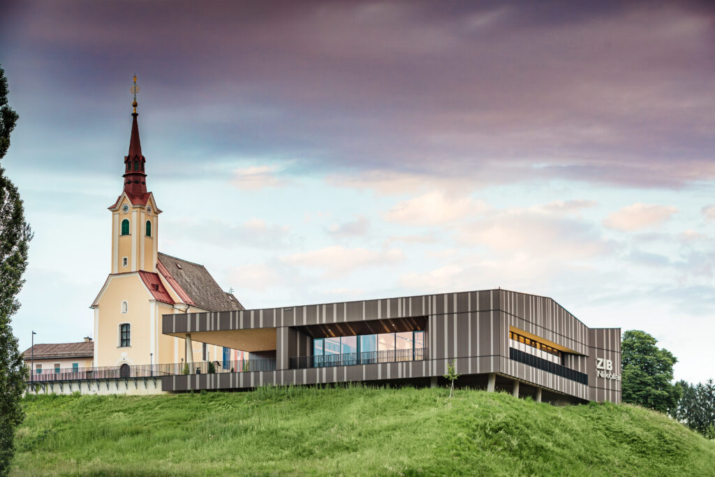 Das farbliche Wechselspiel schafft eine vertikale Gliederung der Fassade, die in einen Dialog mit der benachbarten Kirchenfassade tritt und deren Dominanz im Ortskern bewahrt. Foto: Croce & Wir