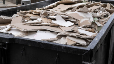 Ein überfüllter Müllcontainer mit Bauschutt und Gipskartonplatten, Schutt, der während des Wiederaufbaus entstanden ist.